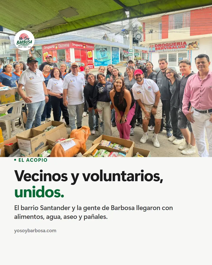 Vecinos y voluntarios, unidos. Grupo de vecinos y voluntarios de Barbosa sonriendo frente a cajas de donaciones en la calle.