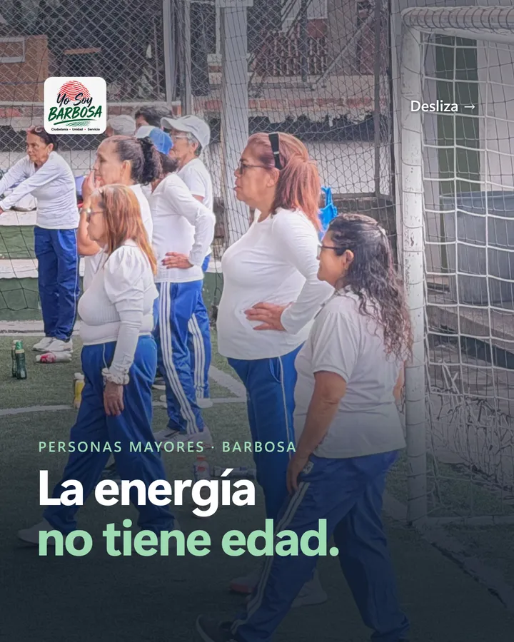 La energía no tiene edad. Mujeres mayores con camiseta blanca y sudadera azul caminan durante una clase de actividad física en una cancha sintética.